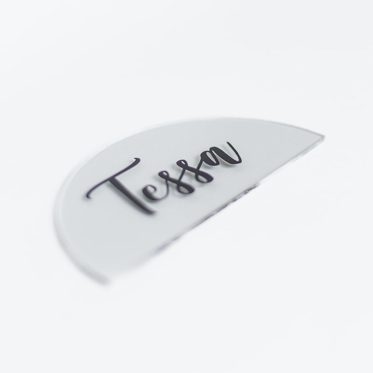 A clear acrylic placecard with black text.