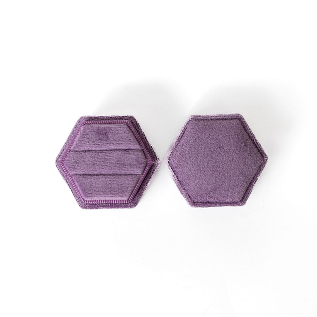 A mauve hexagon ring box lays open displaying the two ring slots in the base.
