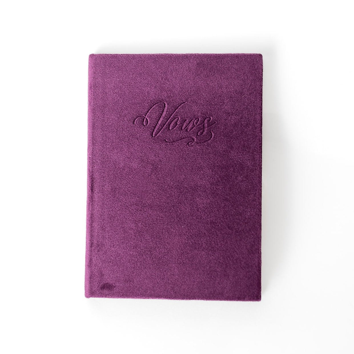 A plum-coloured vow book with the word "Vows" embossed on the front cover.