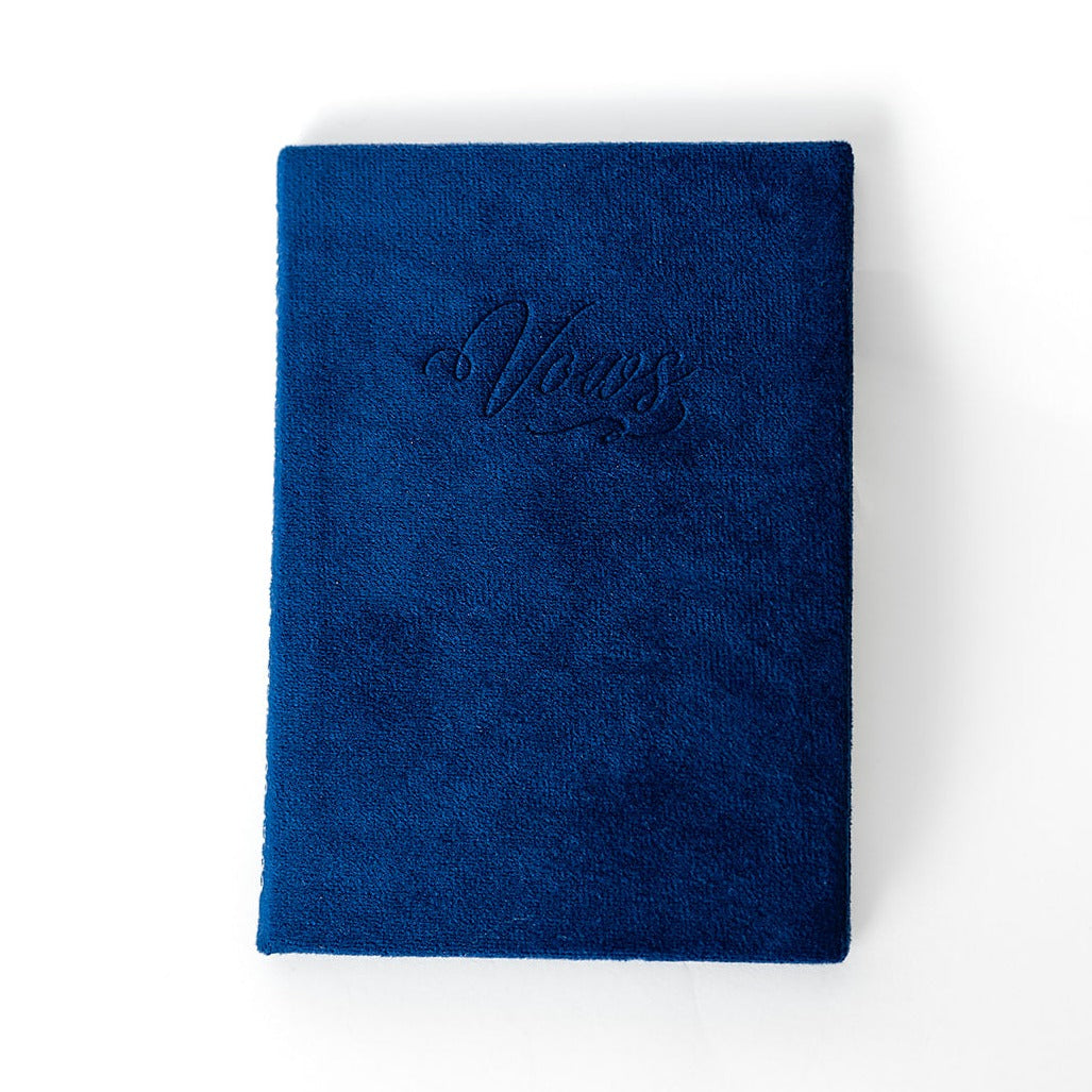 A sapphire vow book with the word "Vows" embossed on the front cover.