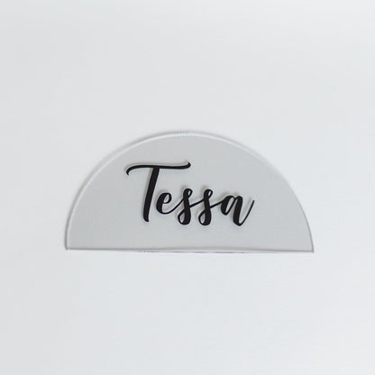 A clear acrylic placecard with black text.