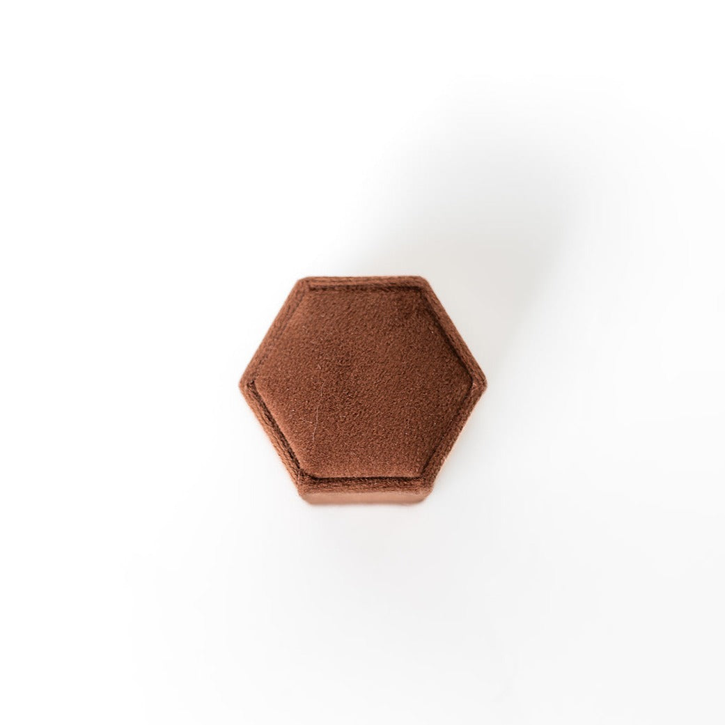 The outside of a chocolate-coloured hexagon ring box.