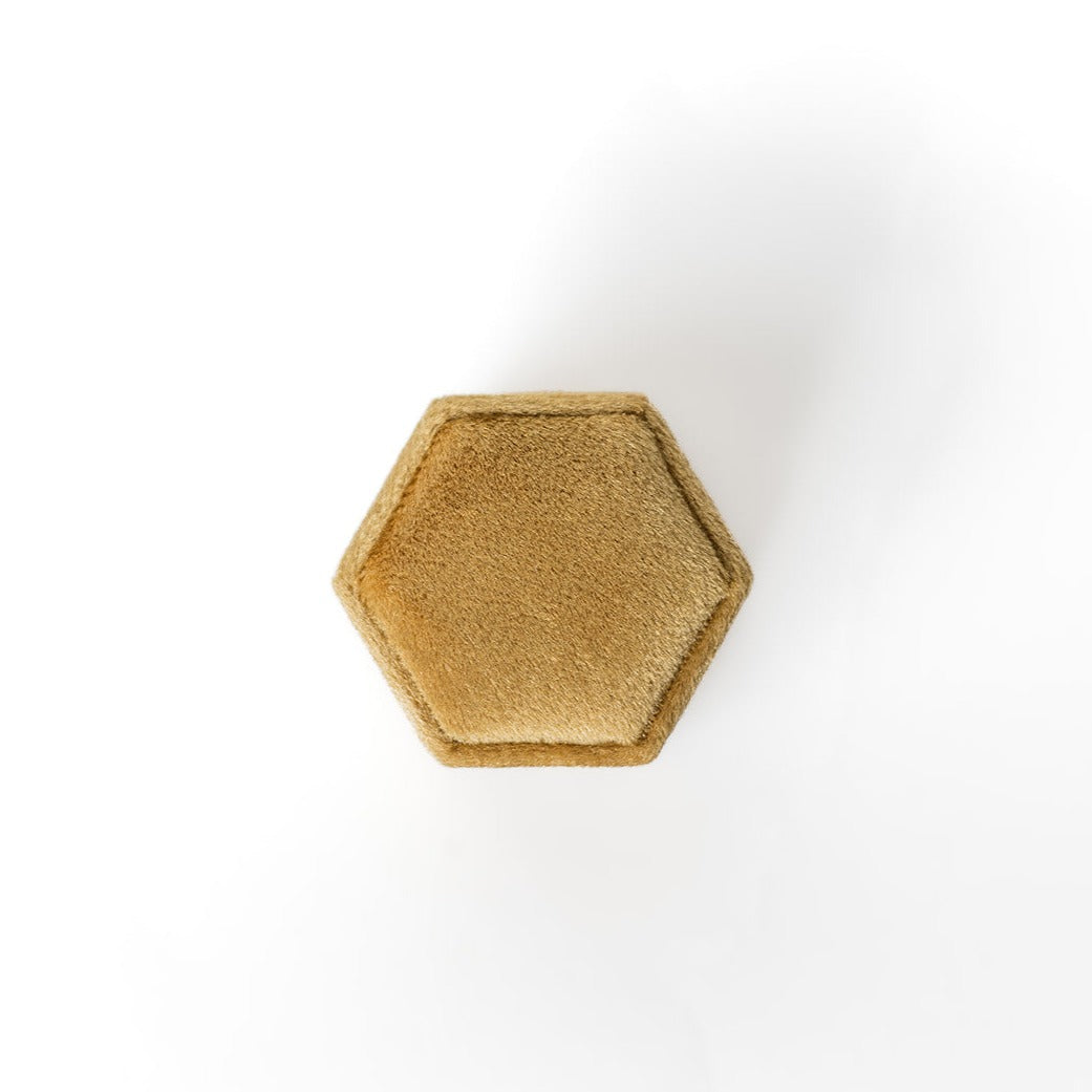 The outside of a mustard-coloured hexagon ring box.