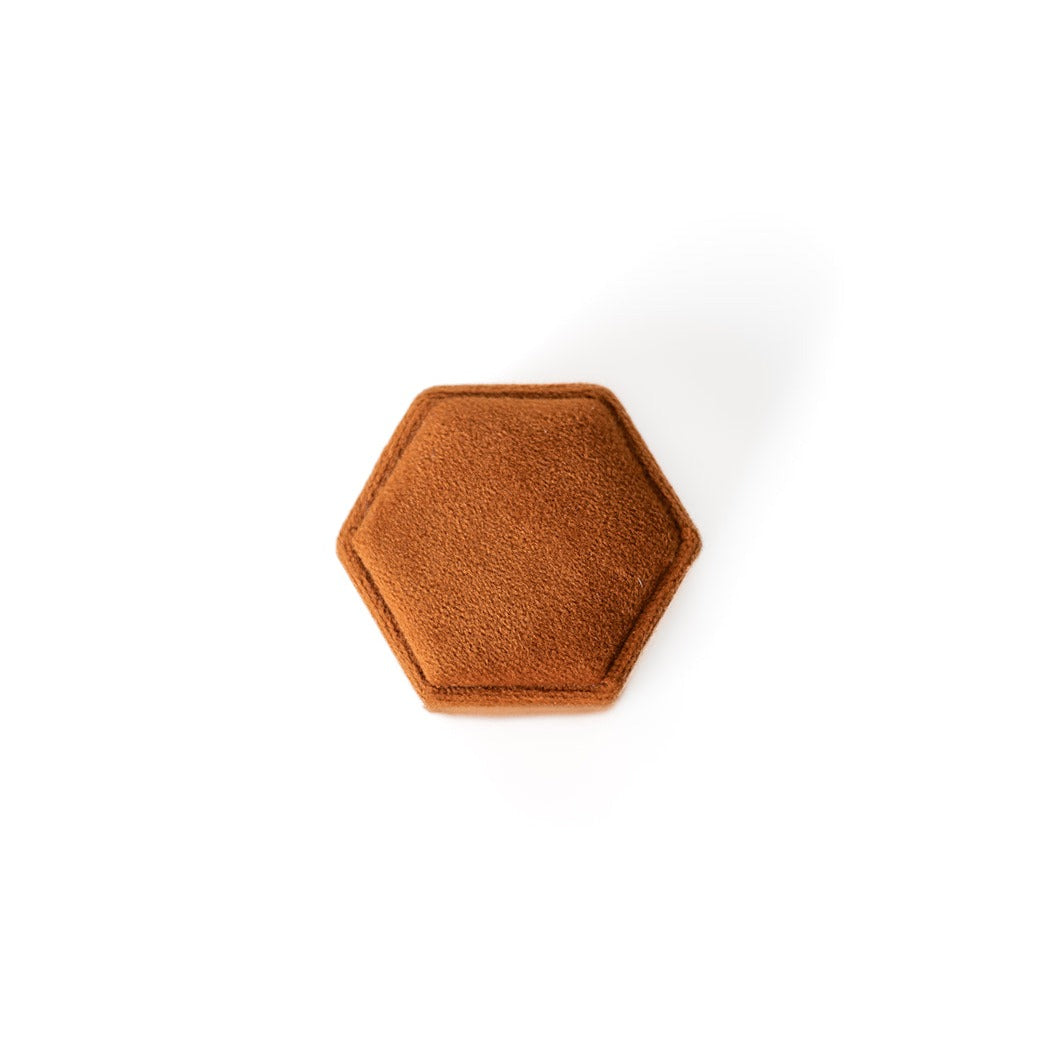 The outside of a burnt orange hexagon ring box.