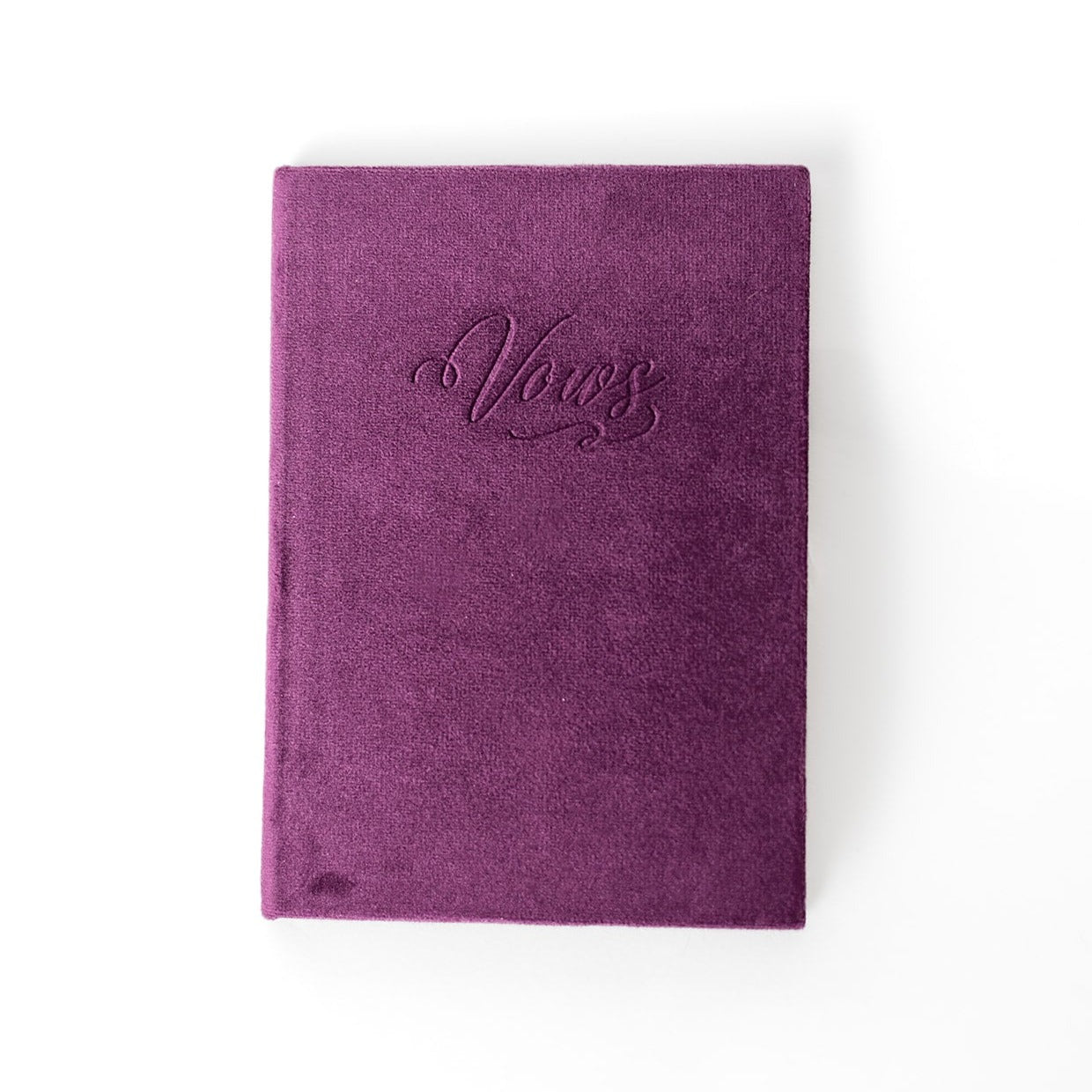 A plum-coloured vow book with the word "Vows" embossed on the front cover.