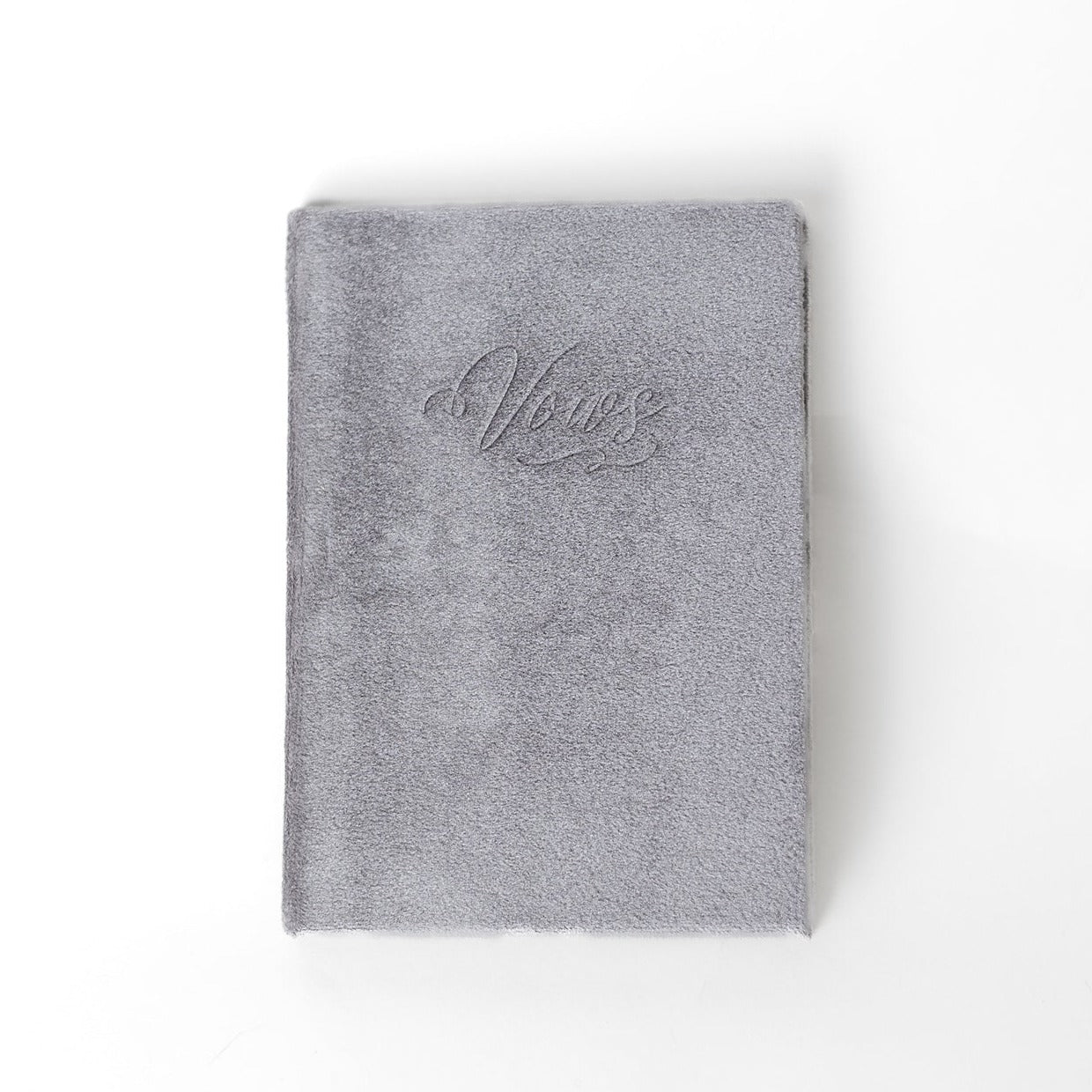 A silver vow book with the word "Vows" embossed on the front cover.