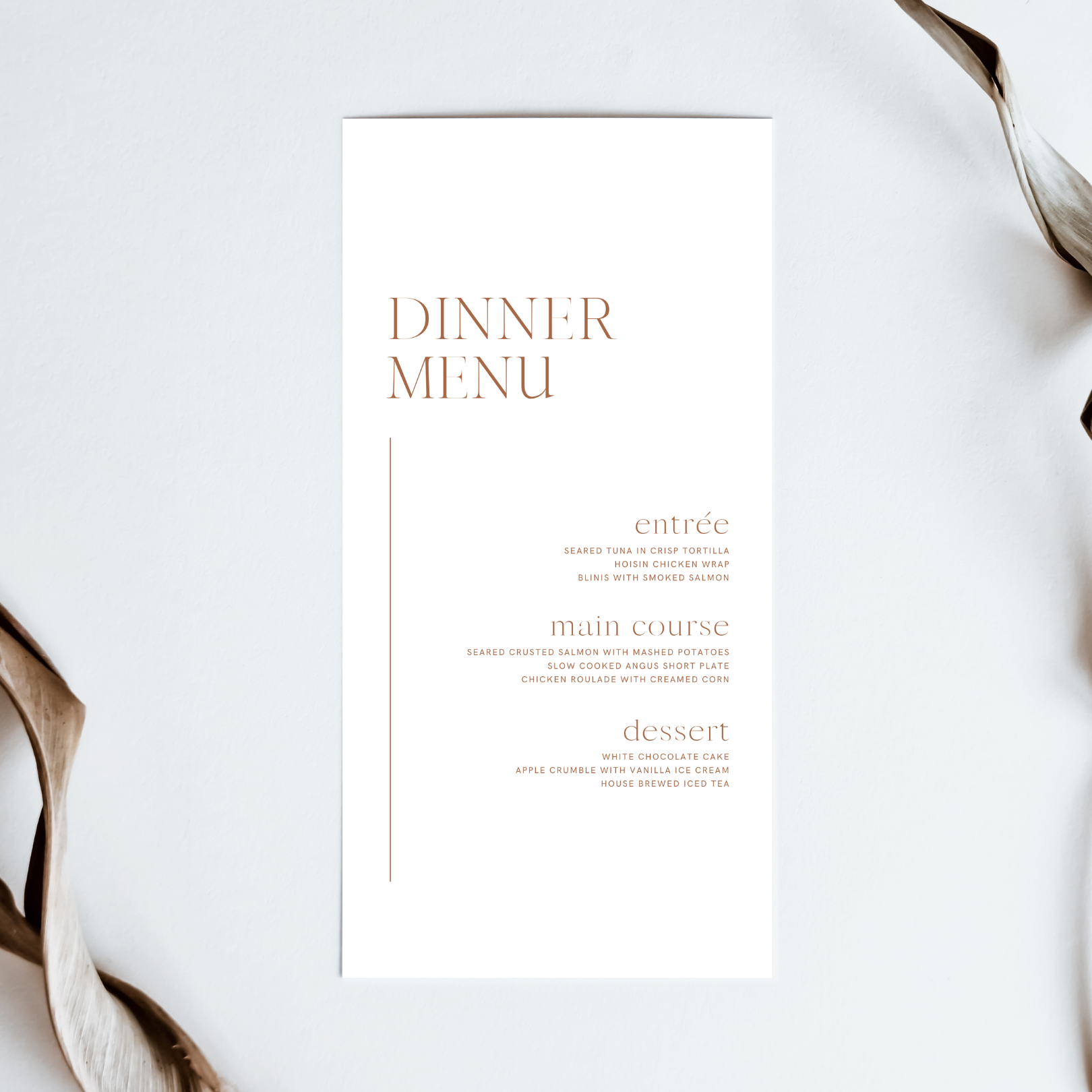 A minimalist, white wedding menu lays on an off-white background. 