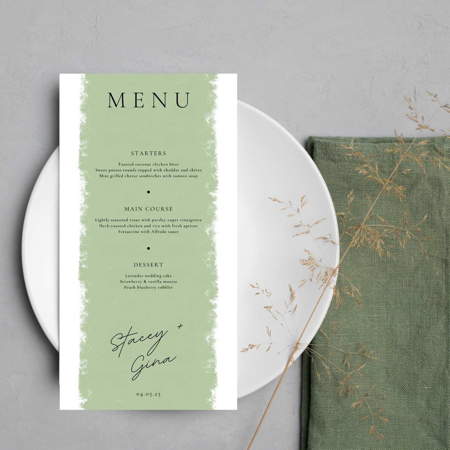 A white and sage coloured wedding menu lays on a round white plate against a light grey background. A small, dried branch of leaves teeters on bottom right the corner of the plate and a folded, olive green napkin is tucked underneath the right hand side of the plate.