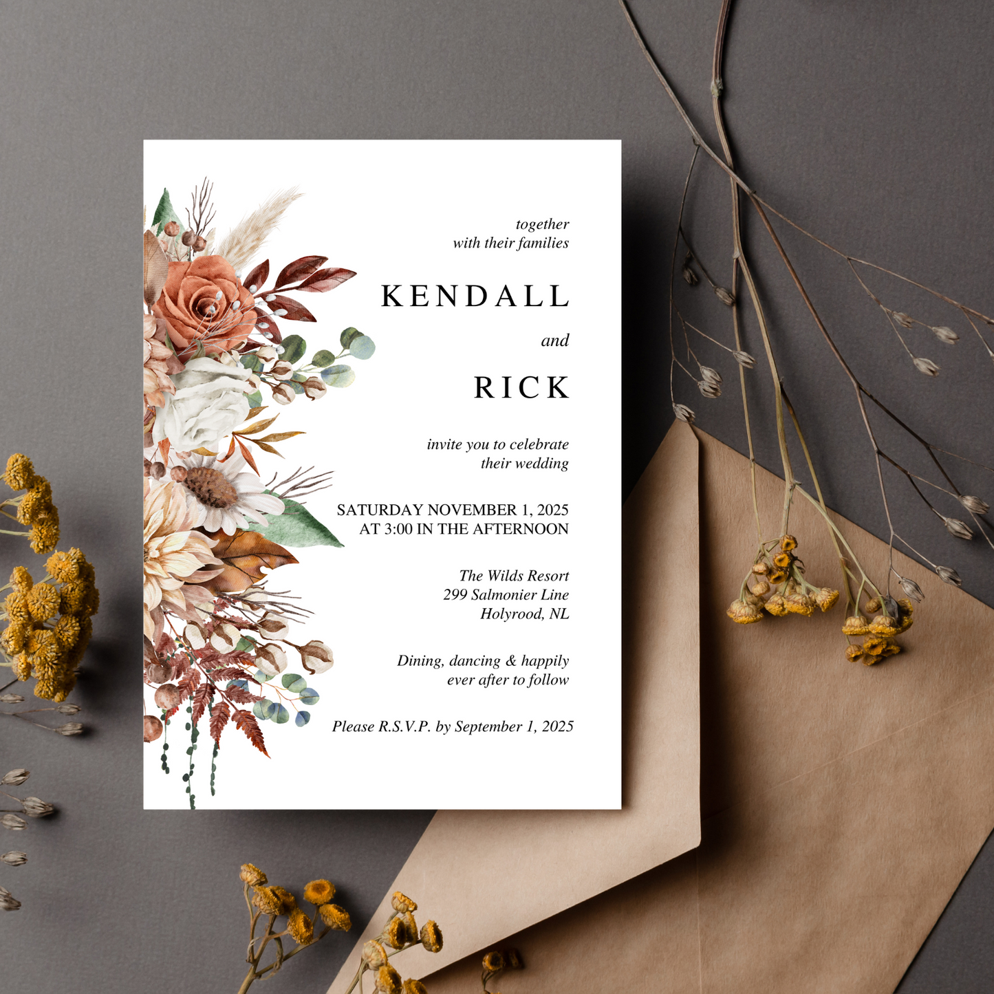A white invitation with a fall coloured bouquet on it's left hand side sits on a charcoal background. There is a kraft paper envelope nestled underneath the wedding invitation with small dark yellow flowers dotting the background.