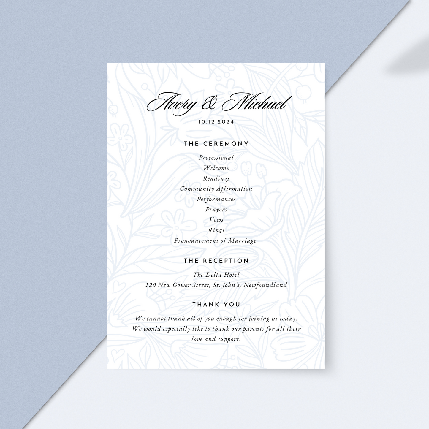 A wedding program with light blue florals in the background lays against a dual blue toned backdrop.
